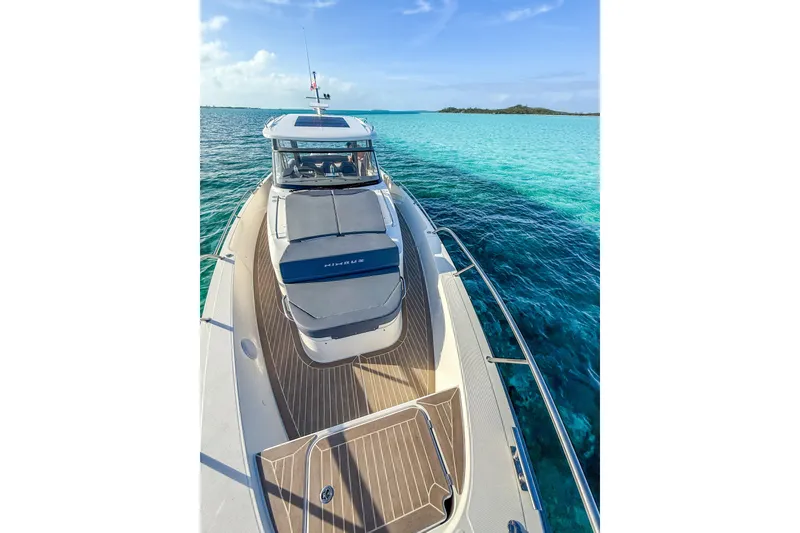 Slide: The Image of 2023 Nimbus Tender 11 yacht cruising on clear turquoise waters. - 14