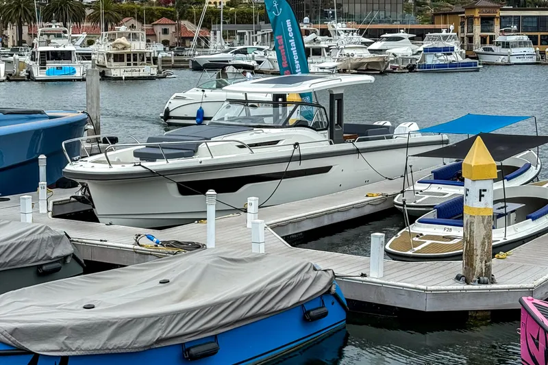 Slide: The Image of 2023 Nimbus Tender 11 docked at a marina, surrounded by other boats. - 16