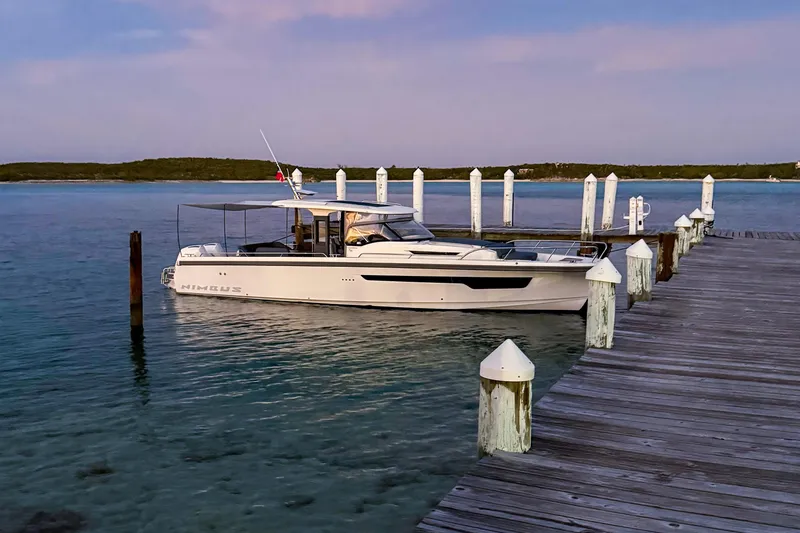 Slide: The Image of 2023 Nimbus Tender 11 docked at a serene waterfront pier during sunset. - 19