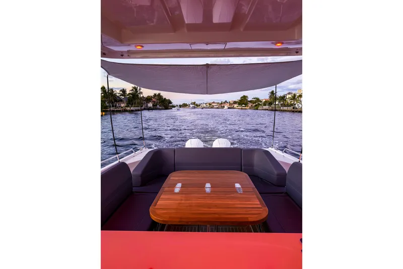 Slide: The Image of 2023 Nimbus Tender 11 boat interior with wooden table, overlooking a scenic waterway. - 20