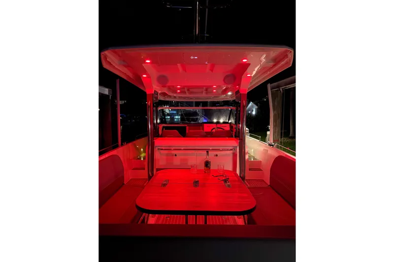 Slide: The Image of 2023 Nimbus Tender 11 boat interior with red ambient lighting at night. - 24