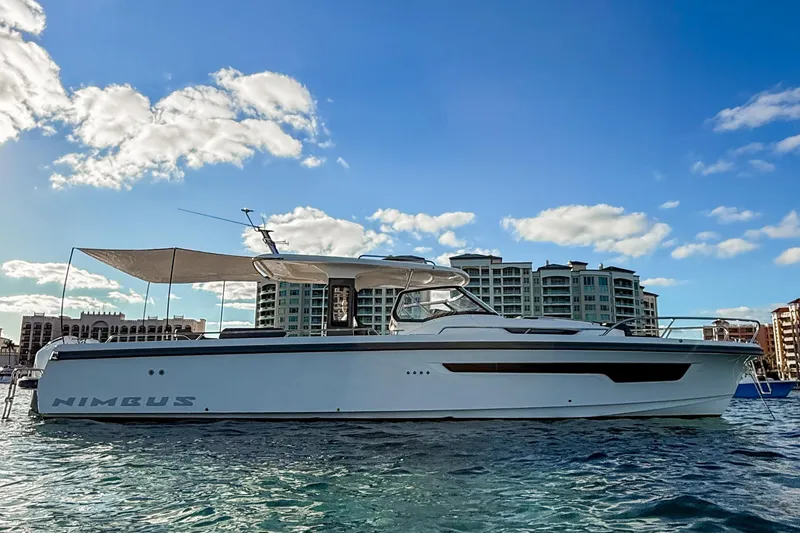 Slide: The Image of 2023 Nimbus Tender 11 yacht on water, with cityscape and blue sky background. - 3