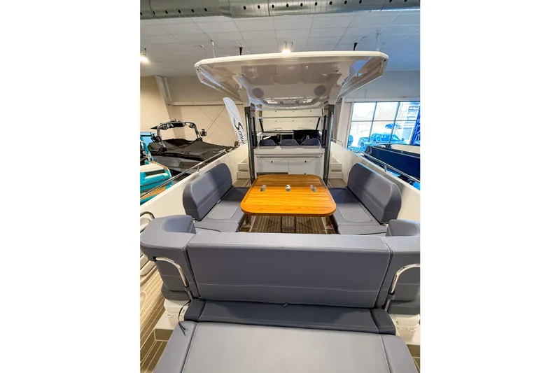 Slide: The Image of 2023 Nimbus Tender 11 boat interior with seating and wooden table in showroom. - 30