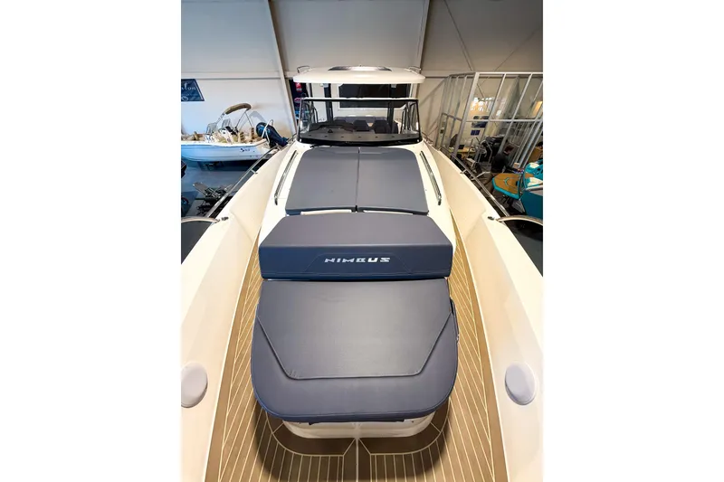 Slide: The Image of 2023 Nimbus Tender 11 boat with cushioned deck, showcased indoors. - 32