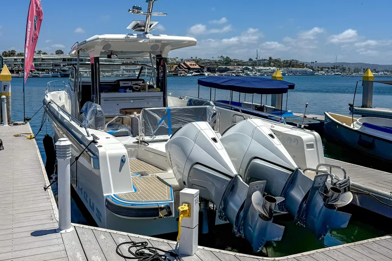 Slide: The Image of 2023 Nimbus Tender 11 docked at marina with twin engines, clear sky background. - 6