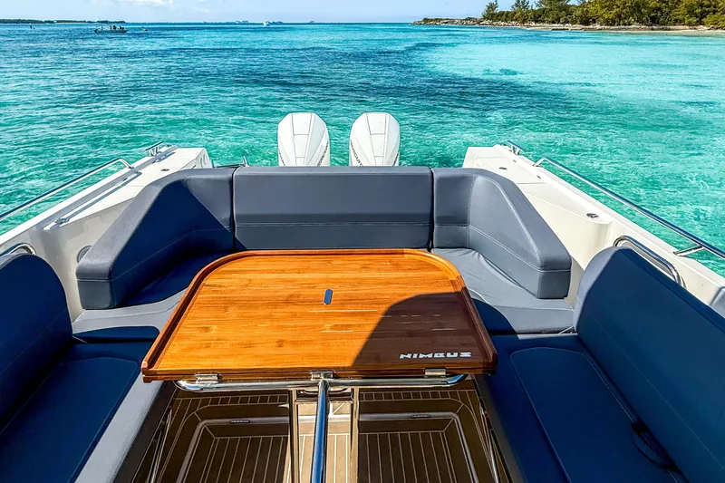 Slide: The Image of 2023 Nimbus Tender 11 boat interior with wooden table, surrounded by turquoise waters. - 9