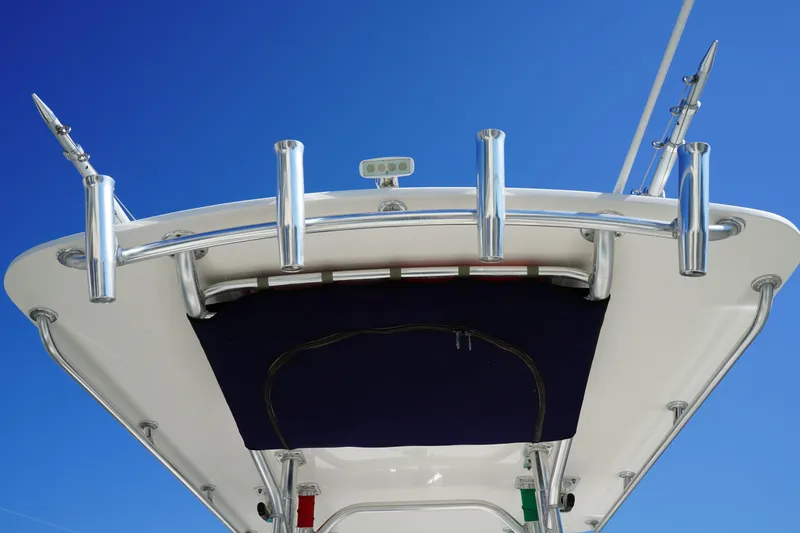 Slide: The Image of 2014 Edgewater 245CC boat with rod holders against a clear blue sky. - 18