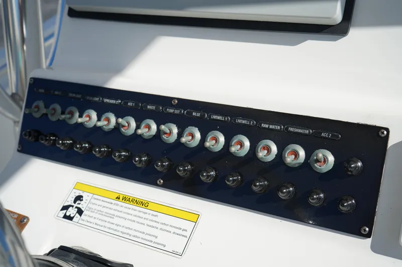 Slide: The Image of Control panel of a 2014 Edgewater 245CC boat with labeled switches and warning sign. - 27