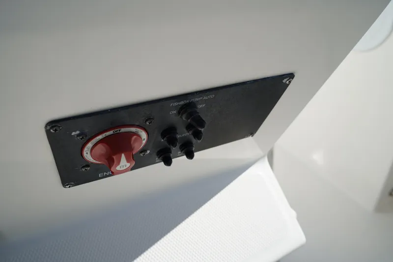 Slide: The Image of Control panel on a 2014 Edgewater 245CC boat, featuring switches and a red dial. - 34