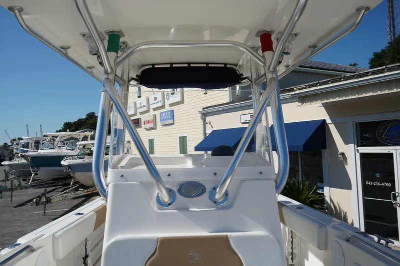Slide: The Image of 2014 Edgewater 245CC boat interior with T-top and marina background. - 39
