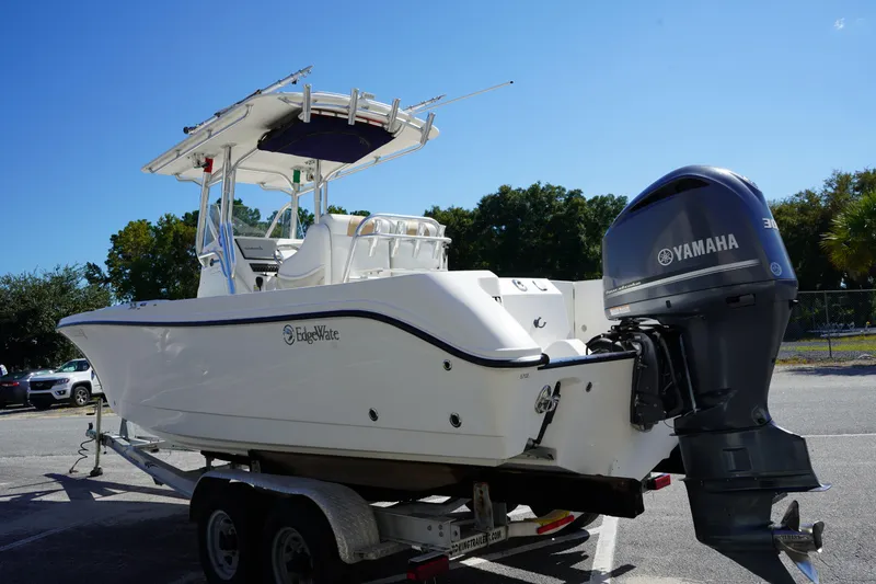 Slide: The Image of 2014 Edgewater 245CC boat on trailer with Yamaha outboard motor, parked outdoors. - 5