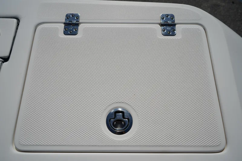 Slide: The Image of Hinged hatch on 2014 Edgewater 245CC boat, featuring textured surface and metal latch. - 9