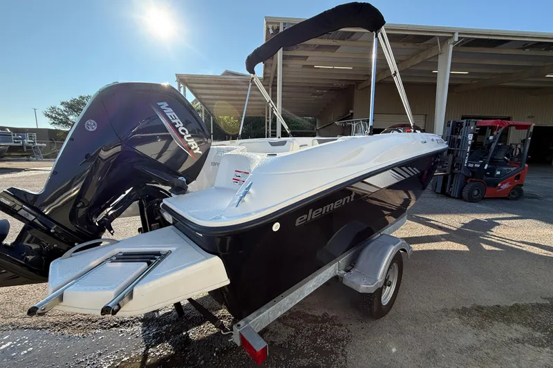 Slide: The Image of 2023 Bayliner Element E18 boat with Mercury engine on trailer, parked outdoors. - 4