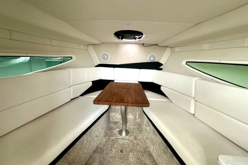 Slide: The Image of 2025 Regal 26 XO boat interior with white seating and wooden table. - 43