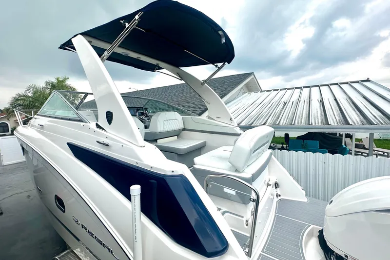 Slide: The Image of 2025 Regal 26 XO boat with sleek design and spacious seating under a cloudy sky. - 9