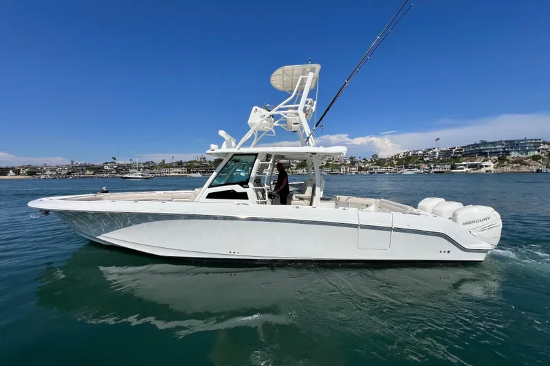 Slide: The Image of 2019 Boston Whaler 380 Outrage boat on calm water, clear sky background. - 0