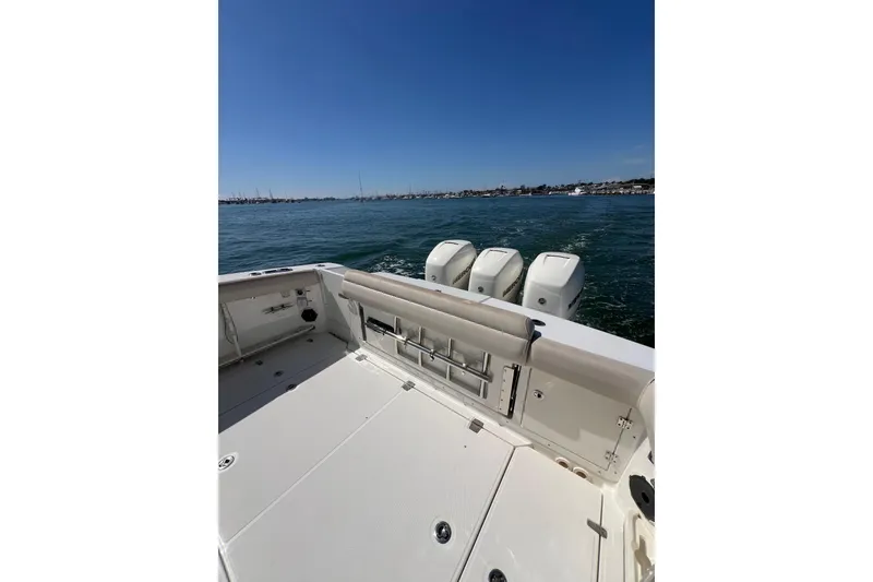 Slide: The Image of 2019 Boston Whaler 380 Outrage boat on water, showcasing spacious deck and powerful engines. - 11