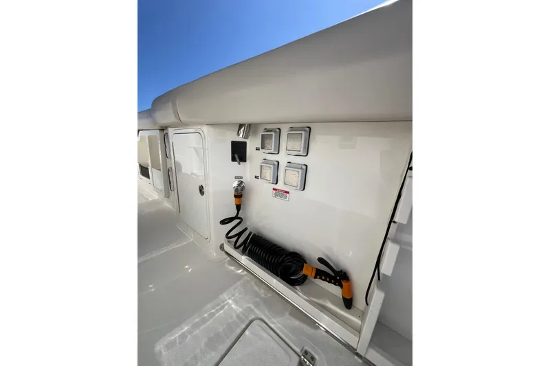 Slide: The Image of 2019 Boston Whaler 380 Outrage deck with utility panel and coiled hose. - 12