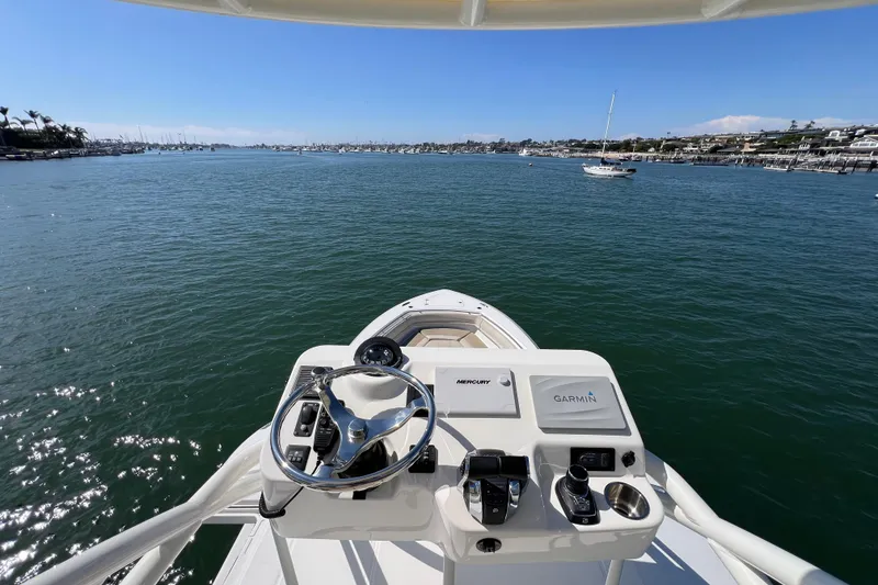 Slide: The Image of 2019 Boston Whaler 380 Outrage helm view, overlooking calm waters and distant shoreline. - 18