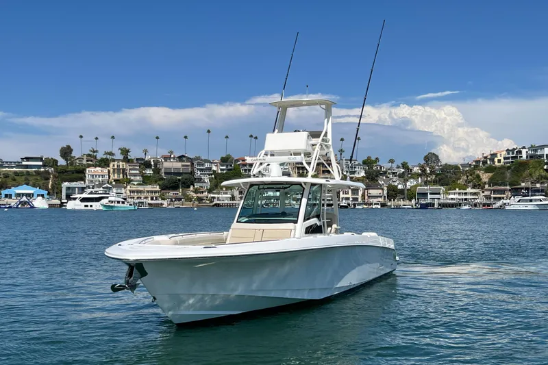 Slide: The Image of 2019 Boston Whaler 380 Outrage boat on water, coastal homes in background. - 19