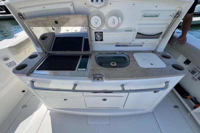 Slide: The Image of 2019 Boston Whaler 380 Outrage boat kitchen with grill, sink, and storage. - 2