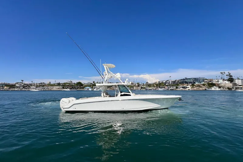 Slide: The Image of 2019 Boston Whaler 380 Outrage boat cruising on a sunny day near coastal buildings. - 22