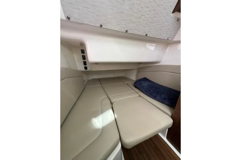 Slide: The Image of 2019 Boston Whaler 380 Outrage cabin interior with beige seating and blue cushion. - 6