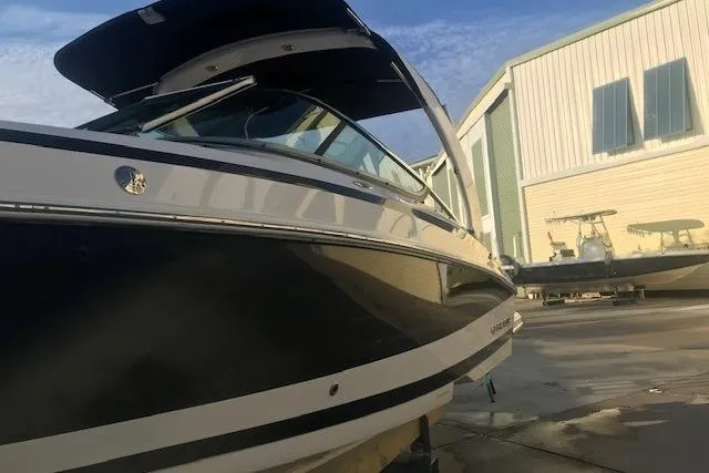 Slide: The Image of 2012 Regal 2500 Bowrider boat in a marina, showcasing sleek design and modern features. - 5