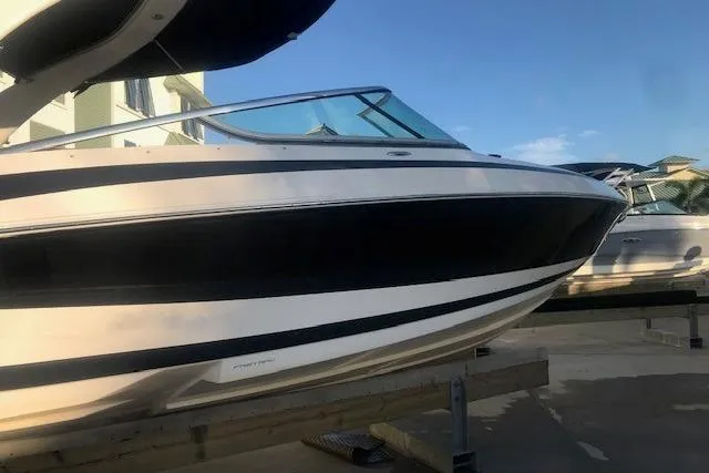 Slide: The Image of 2012 Regal 2500 Bowrider boat on display, featuring sleek black and white design. - 7