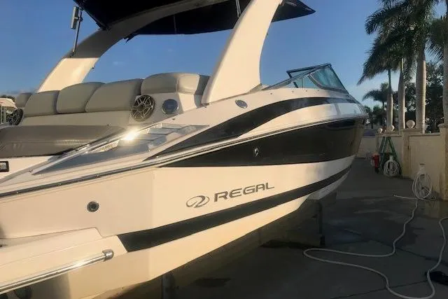 Slide: The Image of 2012 Regal 2500 Bowrider boat docked, featuring sleek design and comfortable seating. - 8