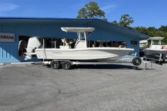 Slide: The Image of 2026 Ranger 2660 Bay boat on trailer, palm trees in background, sunny day. - 1