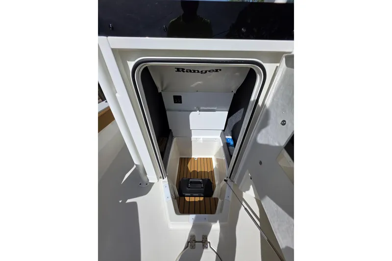 Slide: The Image of 2026 Ranger 2660 Bay boat deck with storage compartments and person standing. - 14