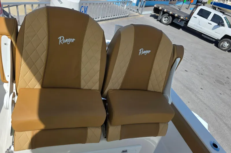 Slide: The Image of 2026 Ranger 2660 Bay boat console with steering wheel and gauges, parked outdoors. - 16