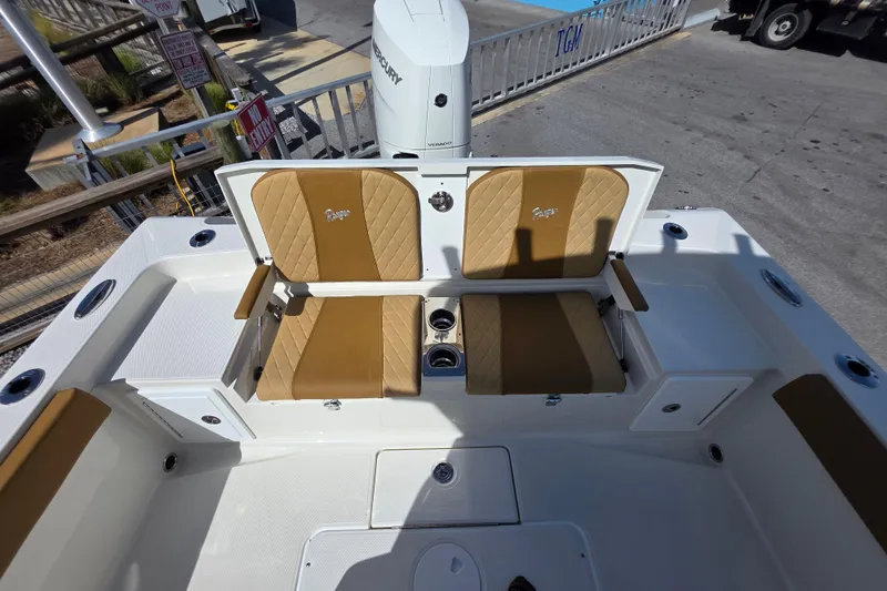 Slide: The Image of 2026 Ranger 2660 Bay boat with tan seating, parked on a sunny street. - 18