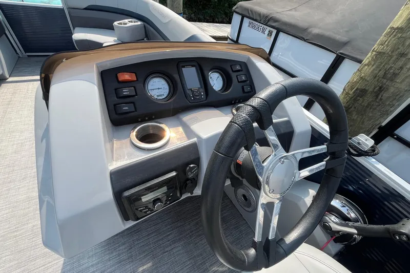 Slide: The Image of 2021 Bennington 21 SSBX boat dashboard with steering wheel and control panel. - 13
