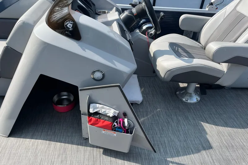 Slide: The Image of Captain's seat and console of 2021 Bennington 21 SSBX boat with storage compartment. - 16