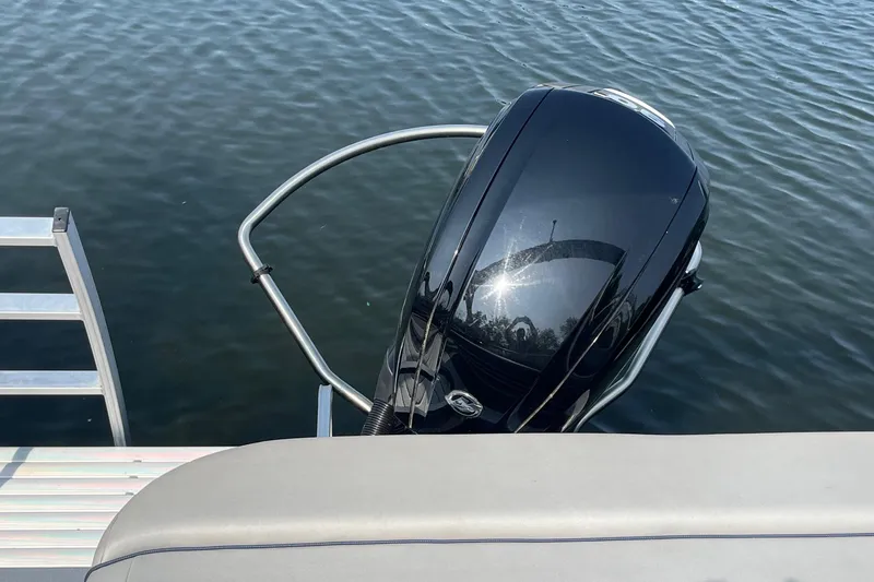 Slide: The Image of 2021 Bennington 21 SSBX boat engine and ladder on calm water. - 24