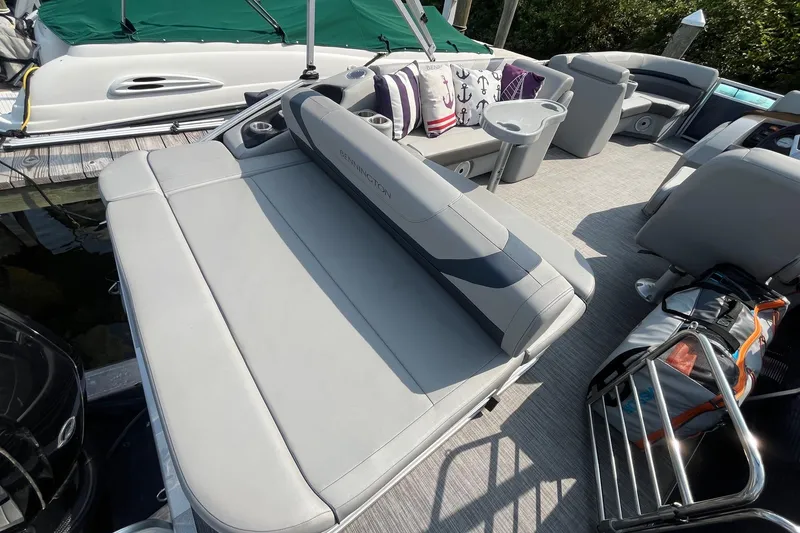 Slide: The Image of 2021 Bennington 21 SSBX pontoon boat interior with cushioned seating and cup holders. - 6