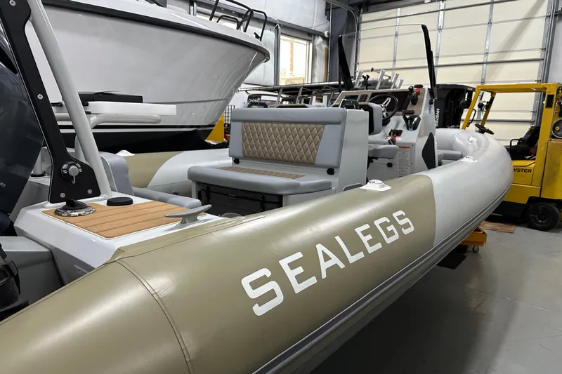 Slide: The Image of 2022 Sealegs 7.5M amphibious boat in a showroom, featuring sleek design and seating. - 12