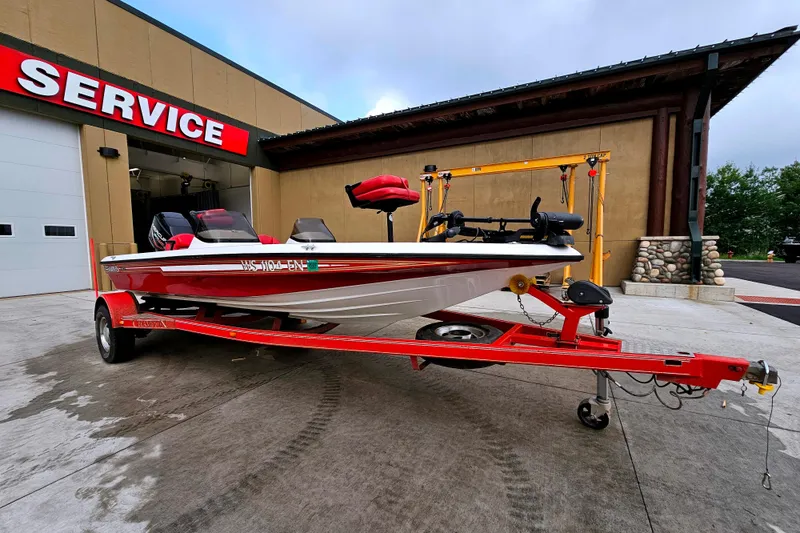 Slide: The Image of 1998 Champion 187 DLX Elite boat on red trailer outside service center. - 1