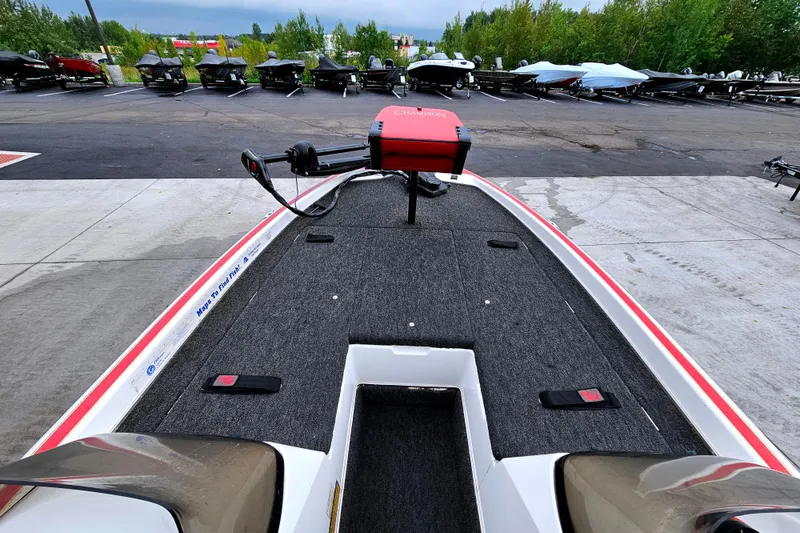 Slide: The Image of 1998 Champion 187 DLX Elite boat with trolling motor, parked in a lot with other boats. - 11