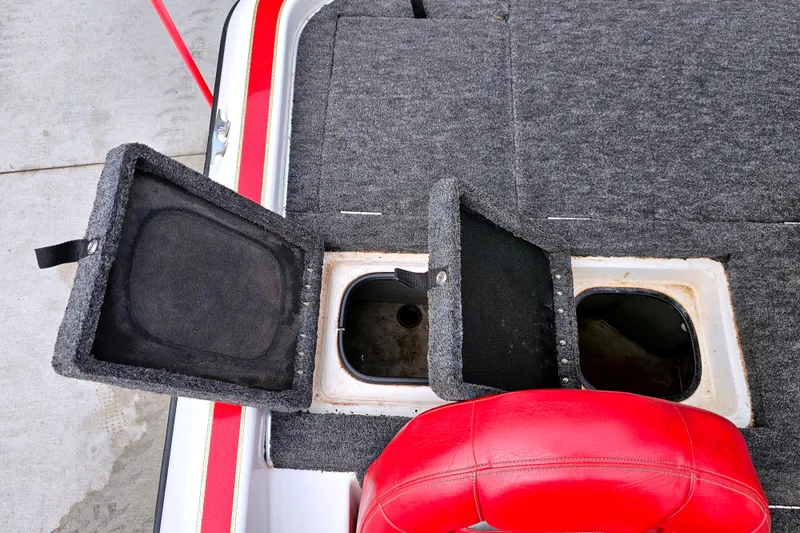 Slide: The Image of 1998 Champion 187 DLX Elite boat storage compartments with open lids and red seat. - 14