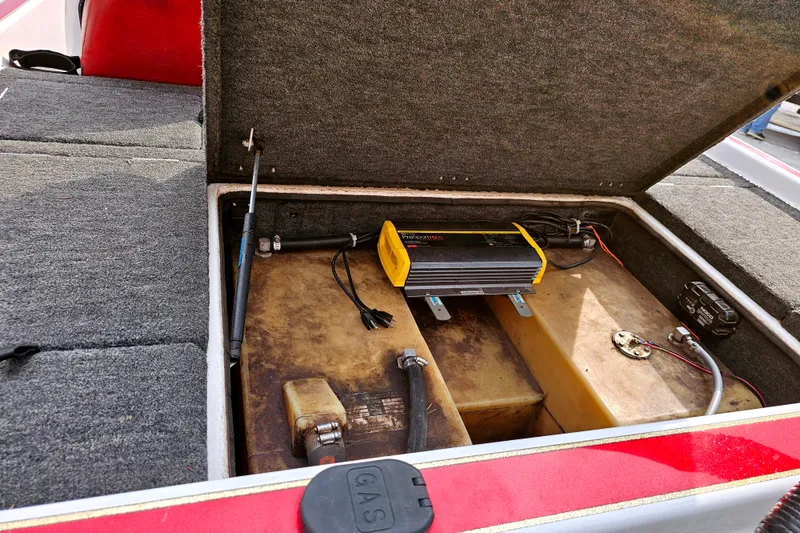 Slide: The Image of Open storage compartment in 1998 Champion 187 DLX Elite boat, showing battery and wiring. - 15