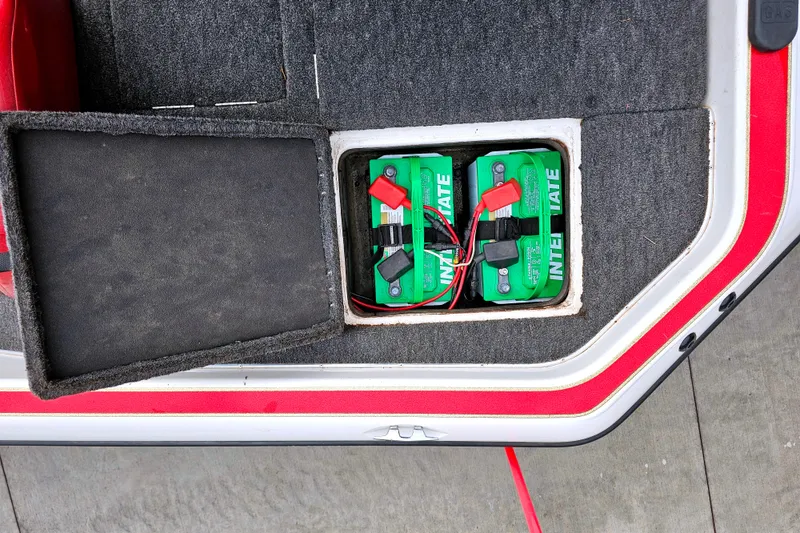 Slide: The Image of 1998 Champion 187 DLX Elite boat battery compartment with two green Interstate batteries. - 16