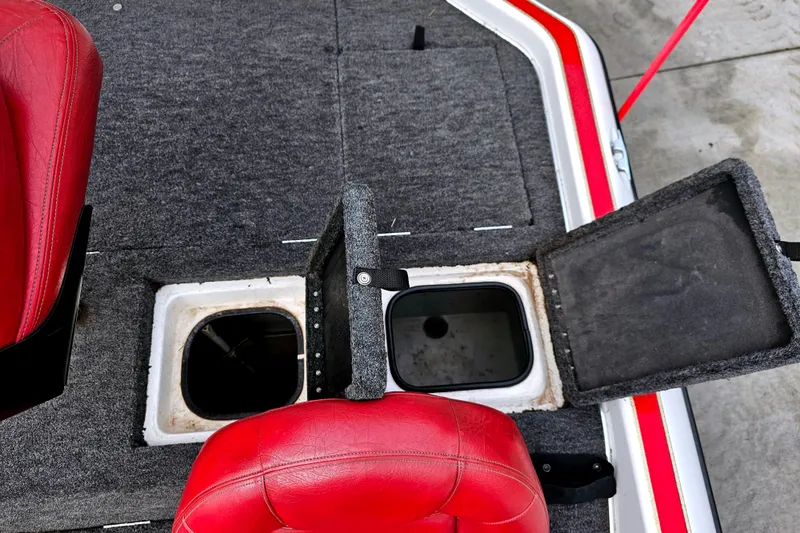 Slide: The Image of 1998 Champion 187 DLX Elite boat interior with red seats and open storage compartments. - 17