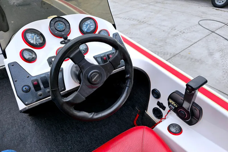 Slide: The Image of 1998 Champion 187 DLX Elite boat dashboard with steering wheel and control panel. - 19