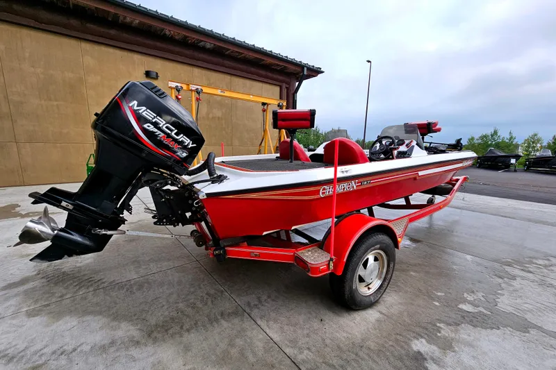 Slide: The Image of 1998 Champion 187 DLX Elite red boat with Mercury outboard motor on trailer. - 2