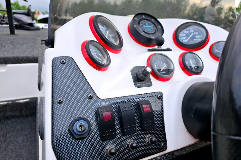 Slide: The Image of Dashboard of a 1998 Champion 187 DLX Elite boat with gauges and controls. - 21