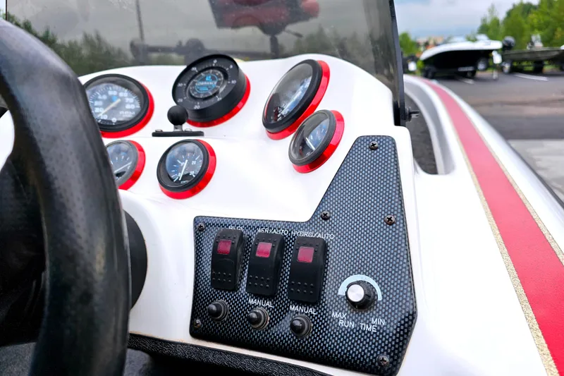 Slide: The Image of Dashboard of a 1998 Champion 187 DLX Elite boat with gauges and controls. - 22