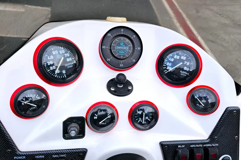 Slide: The Image of Dashboard of a 1998 Champion 187 DLX Elite boat with gauges and controls. - 23